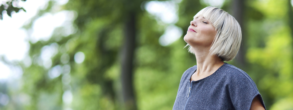 Woman standing outside breathing in fresh air