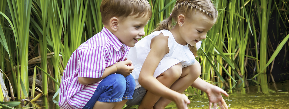 A boy and girl playing in the grass.