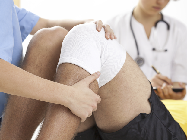 Doctor examining patients knees