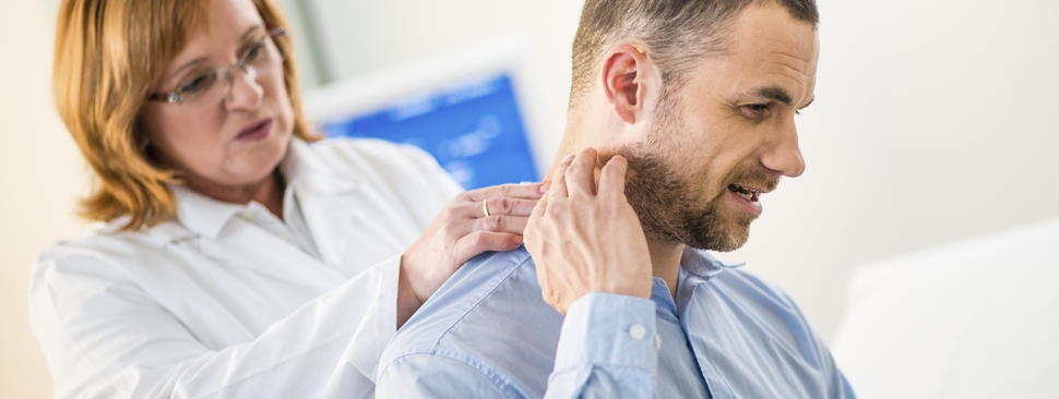 Female doctor examining patient's back in the clinic.