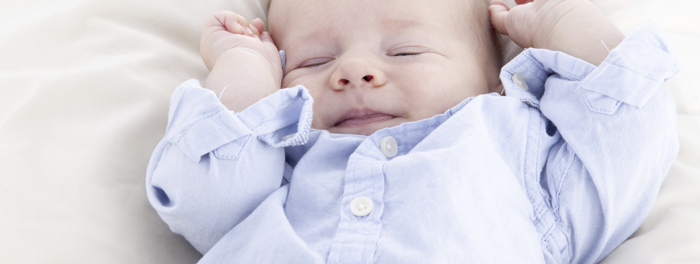 A happy baby lays on his back