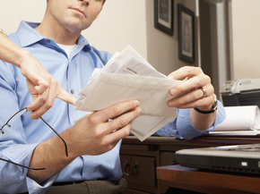 Man holding envelopes.