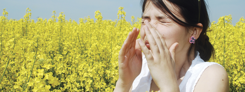 Woman sneezing in a field of flowers
