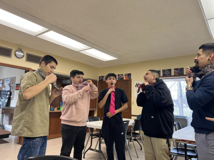 Young men tying ties