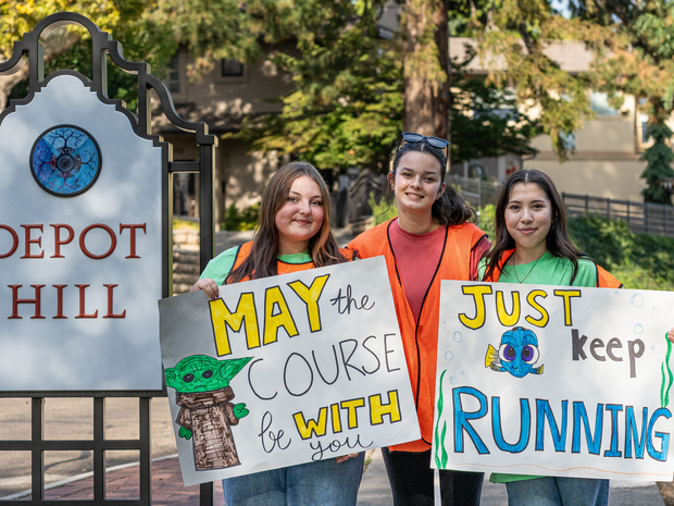 FitOne volunteers hold encouraging race signs
