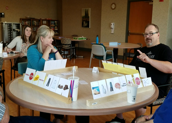 Man and woman sitting at table playing cards