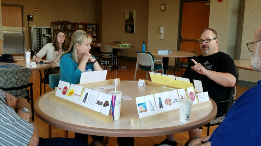 Man and woman sitting at table playing cards