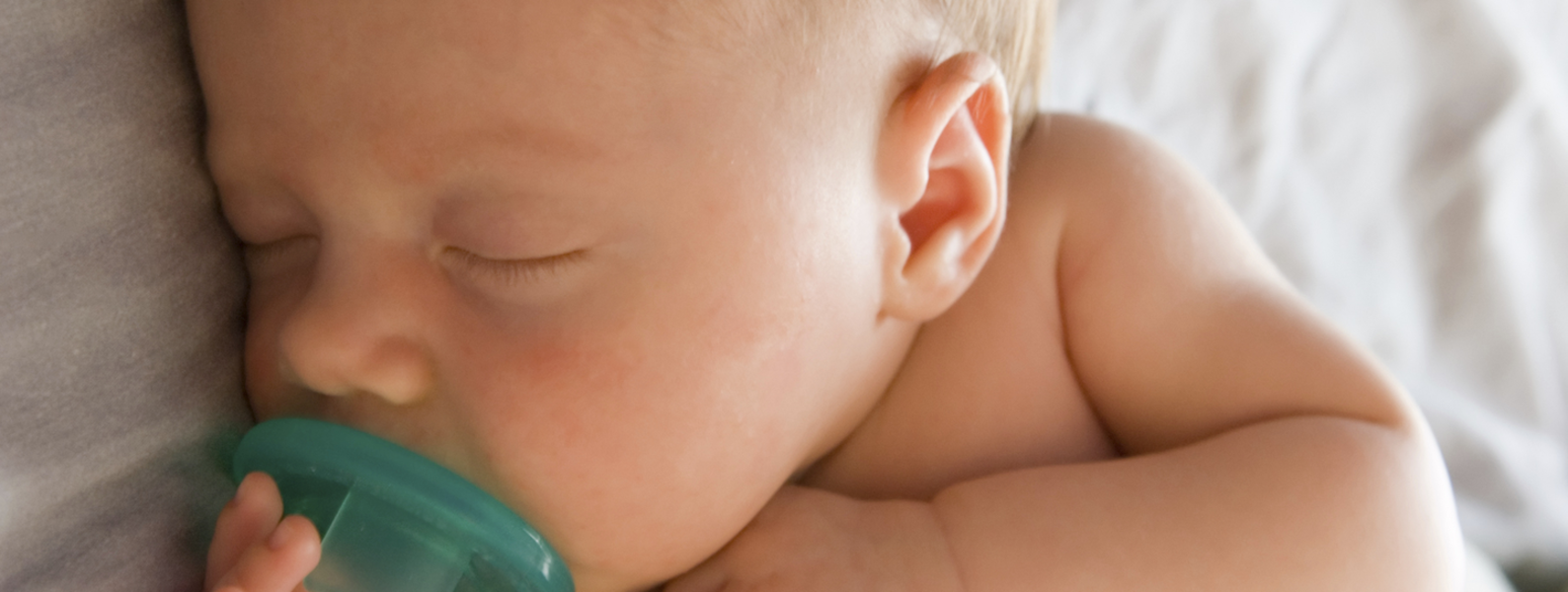 Baby sleeping with a pacifier.