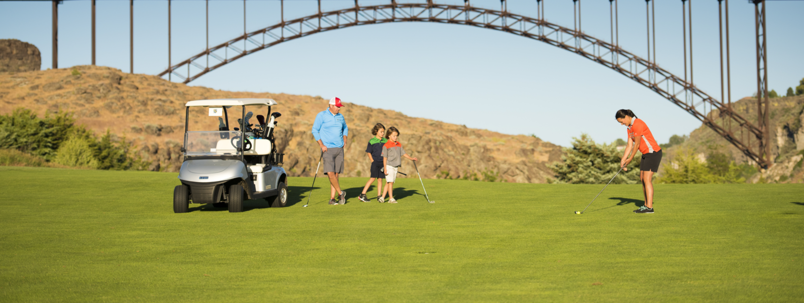 Family watching golfer hit her ball.