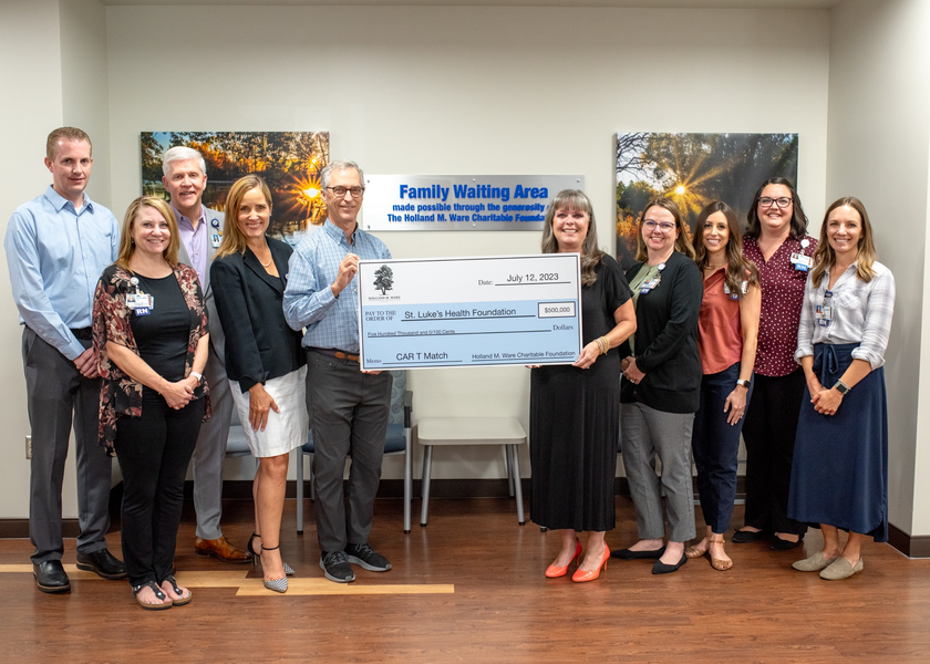 Group of people hold large check