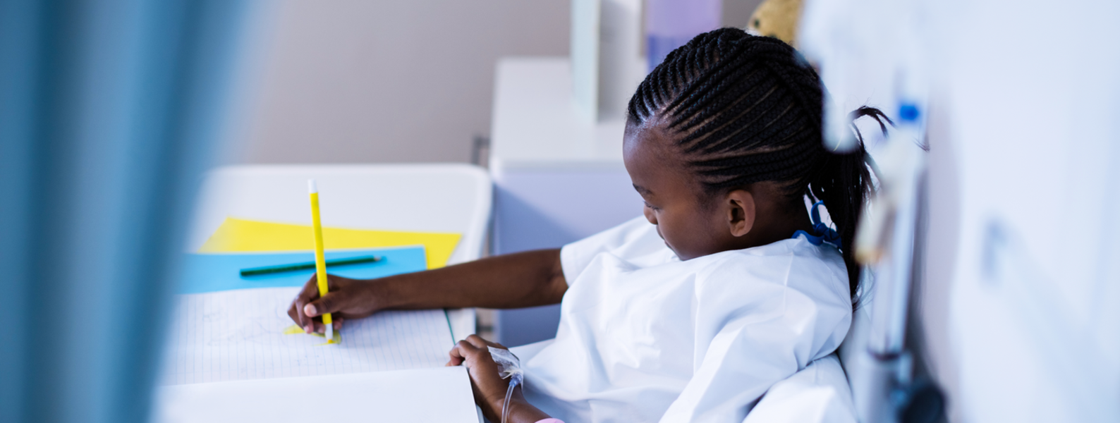 A hospitalized child draws in bed.