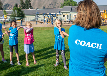 Kids stretching under the guidance of a coach.