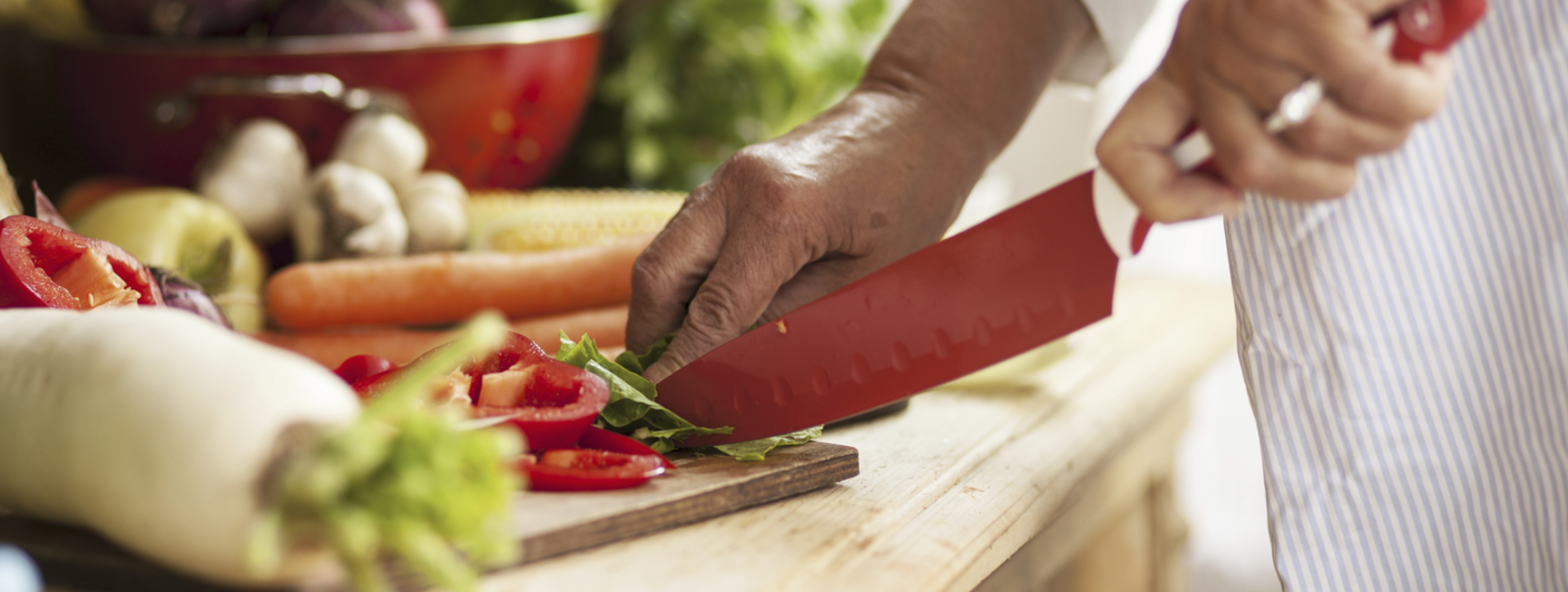Chef cutting vegetables on a board.