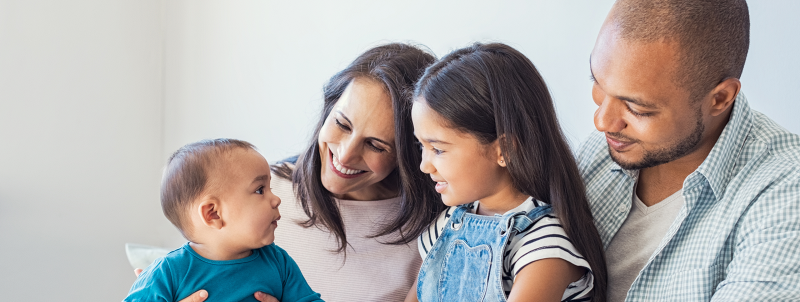 A family laughing together on a sofa.