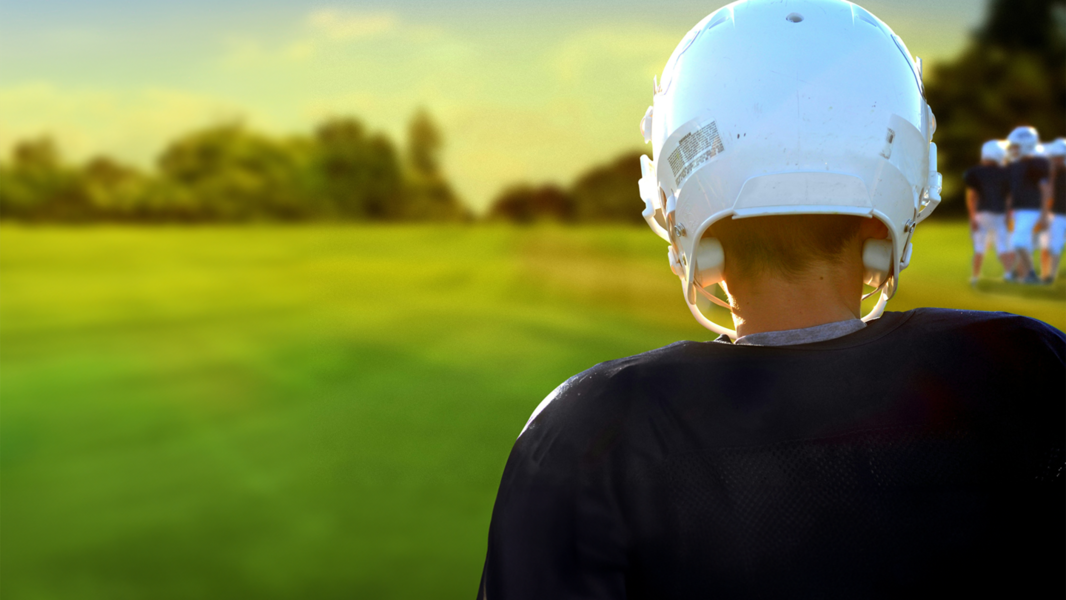 Back of young football player with helmet on