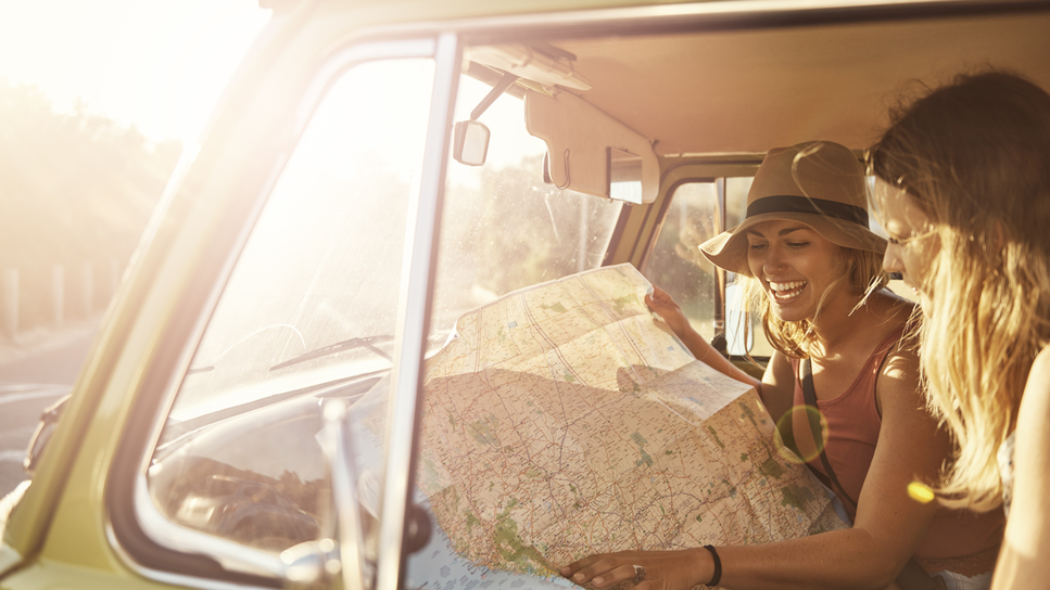 Two girls in a van with a map.