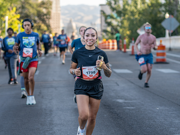 Woman running FitOne with her phone in her hand.