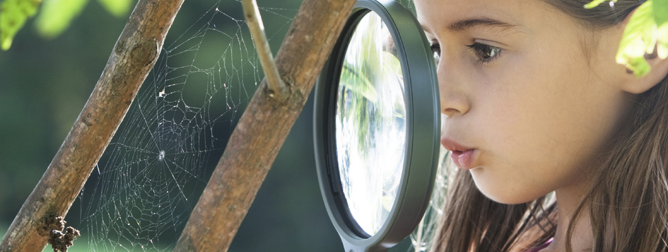 Girl looking through magnifying glass