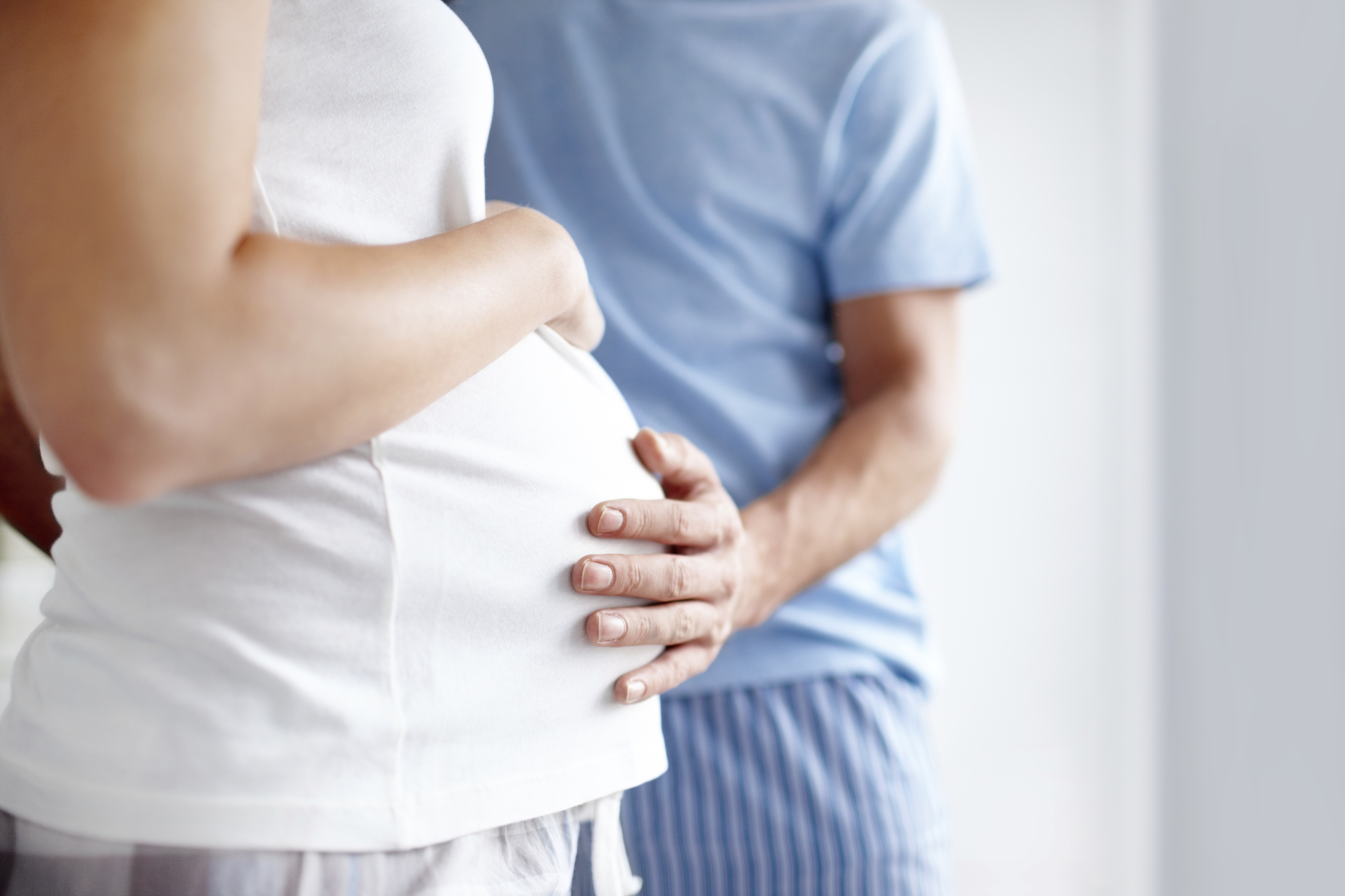 Father touches mother's pregnant belly