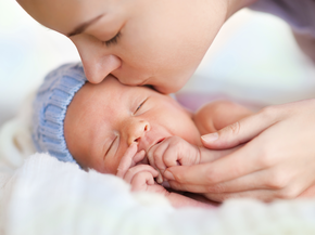 Newborn baby kissed by mother