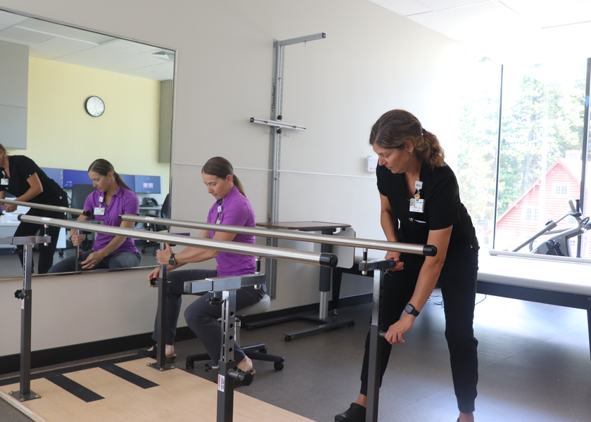  Two women assemble parallel bars