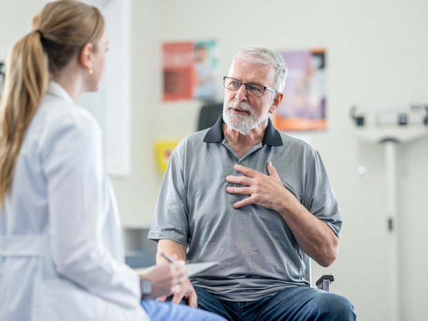 Older man talking to his provider with his hand on his chest