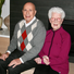 Gail and Jim pose while sitting on a bench at an event.
