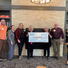 Group of people pose with a large donor check from Imogene.
