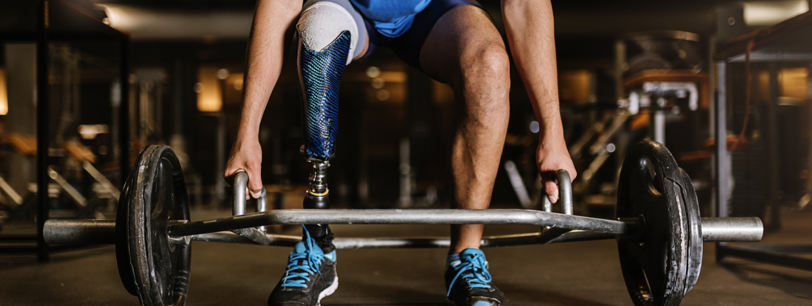 A weight lifter with a prosthetic leg ready to lift barbell.