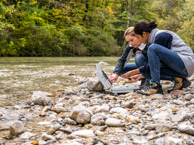 Two scientists testing river water