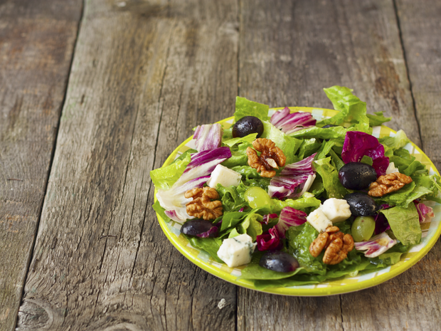 A plate of salad on an outdoor table.