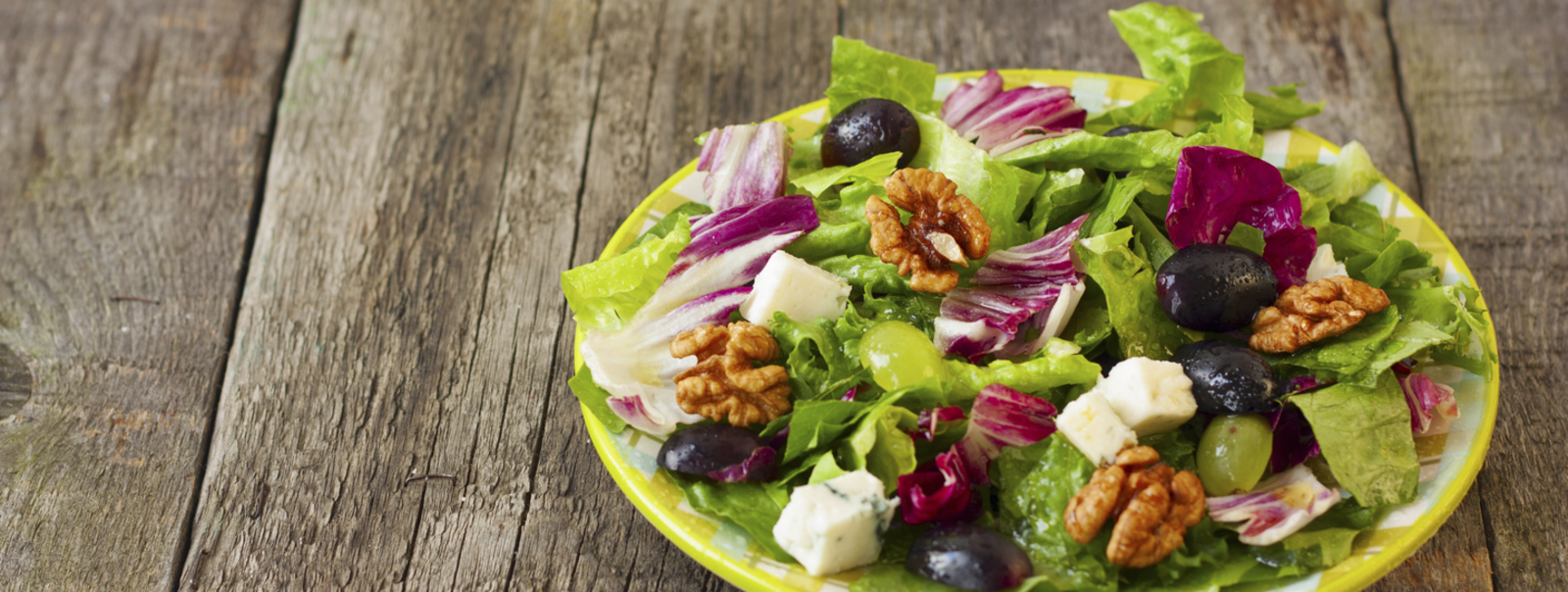 A plate of salad on an outdoor table.