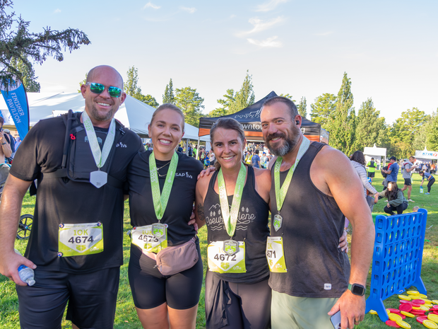 Four FitOne race participants with their finisher medals.