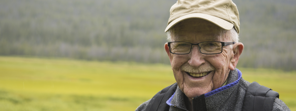 Older man smiles into the camera