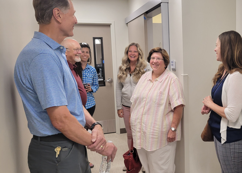 People conversing in clinic corridor